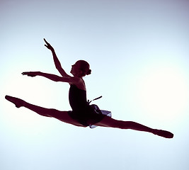 Image showing Beautiful young ballet dancer jumping on a gray background. 