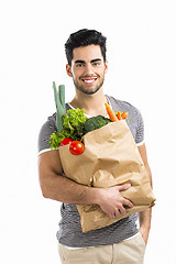 Image showing Man carrying a bag full of vegetables