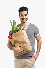 Image showing Man carrying a bag full of vegetables