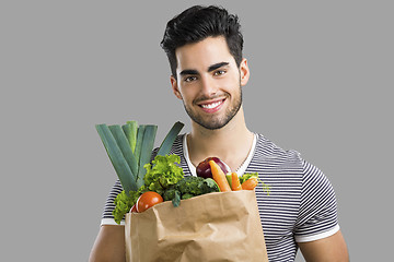 Image showing Man carrying a bag full of vegetables