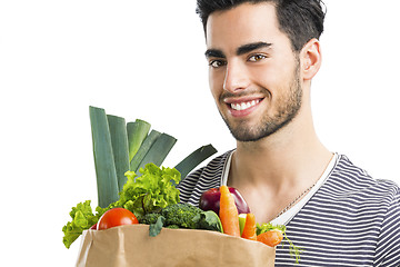 Image showing Man carrying a bag full of vegetables