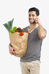 Image showing Man carrying a bag full of vegetables