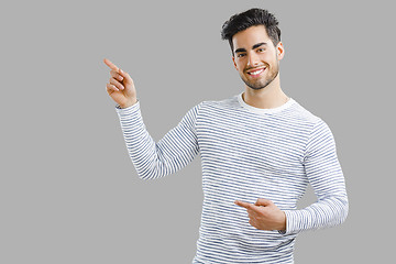 Image showing Handsome young man pointing