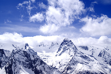 Image showing Snowy mountains in clouds at sun day