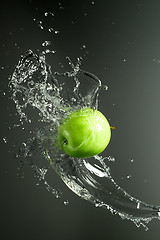 Image showing Green apple with water splash, on black