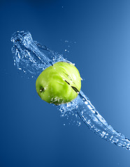 Image showing Green apple with water splash, on blue water