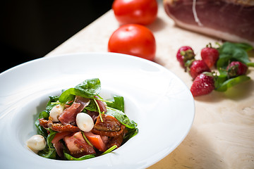 Image showing Salad with strawberry, prosciutto, herbs, cottage cheese and blackberry balsamic vinegar.