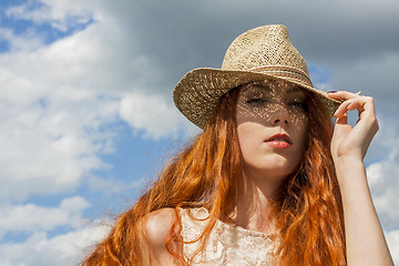 Image showing Gorgeous Woman in Hat on Cloudy Sky background