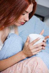 Image showing Pensive Woman Having an Early Coffee at her Bed