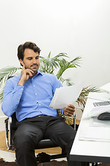 Image showing Young man reading written agreements for work