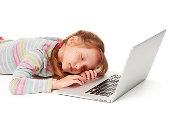 Image showing Exhausted little gir sleeping on laptop keyboard