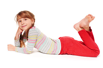 Image showing Side view of smiling child girl lying on stomach