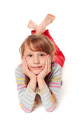 Image showing Front view of smiling child girl lying on stomach