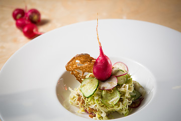 Image showing Salad from cabbage, herbs, cucumber and radish in bowl.