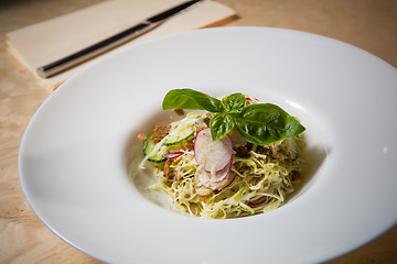 Image showing Salad from cabbage, herbs, cucumber and radish in bowl.