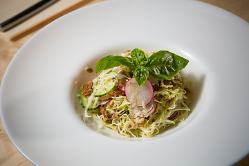 Image showing Salad from cabbage, herbs, cucumber and radish in bowl.