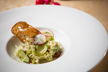 Image showing Salad from cabbage, herbs, cucumber and radish in bowl.