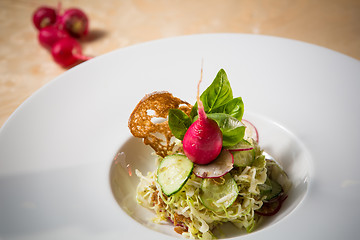 Image showing Salad from cabbage, herbs, cucumber and radish in bowl.