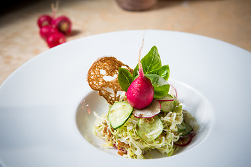 Image showing Salad from cabbage, herbs, cucumber and radish in bowl.