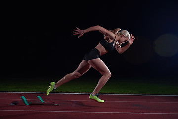 Image showing woman  sprinter leaving starting blocks