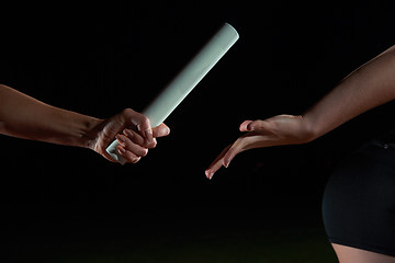 Image showing athletic runners passing baton in relay race