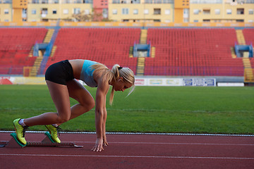 Image showing woman  sprinter leaving starting blocks