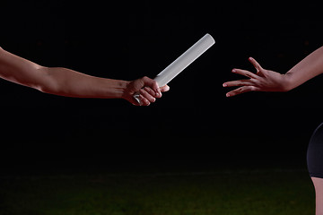 Image showing athletic runners passing baton in relay race