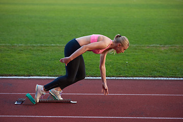 Image showing woman  sprinter leaving starting blocks