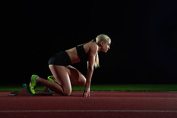 Image showing woman  sprinter leaving starting blocks