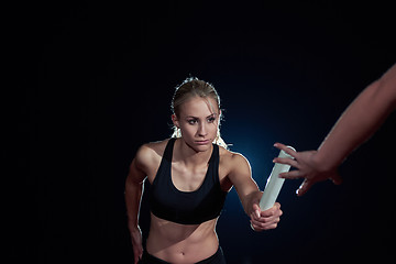 Image showing athletic runners passing baton in relay race