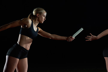 Image showing athletic runners passing baton in relay race