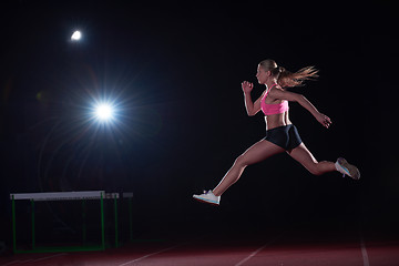 Image showing Athletic woman running on track