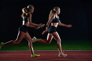 Image showing athletic runners passing baton in relay race