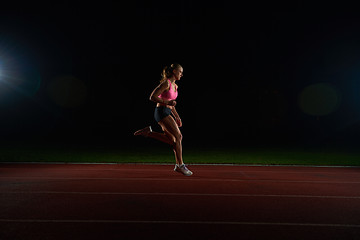 Image showing Athletic woman running on track