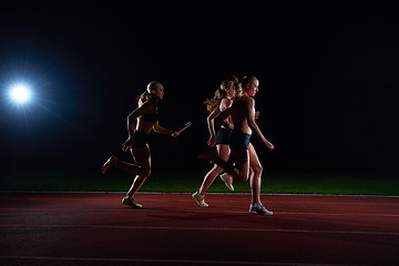 Image showing athletic runners passing baton in relay race