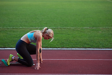 Image showing woman  sprinter leaving starting blocks