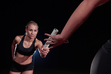 Image showing athletic runners passing baton in relay race