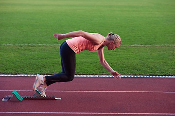 Image showing woman  sprinter leaving starting blocks