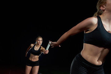 Image showing athletic runners passing baton in relay race