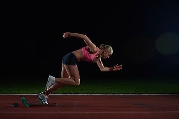 Image showing woman  sprinter leaving starting blocks