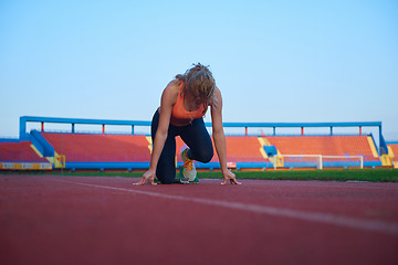 Image showing woman  sprinter leaving starting blocks