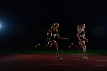 Image showing athletic runners passing baton in relay race