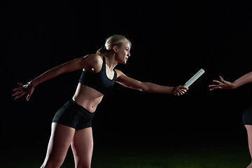 Image showing athletic runners passing baton in relay race