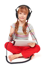 Image showing Little girl enjoying music listening in headphones