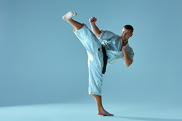 Image showing Man in white kimono training karate