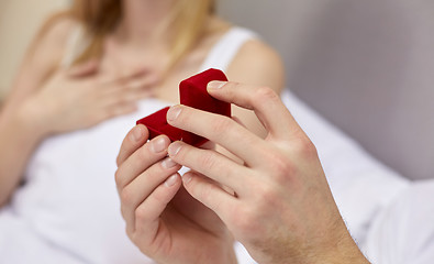 Image showing close up of hands holding little red gift box