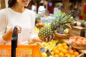 Image showing close up of woman with pineapple in grocery market