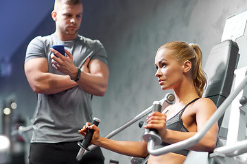 Image showing man and woman flexing muscles on gym machine