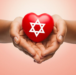 Image showing close up of hands holding heart with jewish star