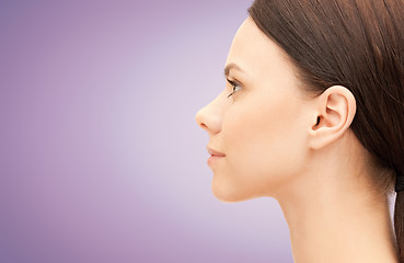 Image showing beautiful young woman face over violet background